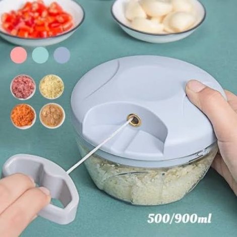Hand pulling string of manual vegetable chopper on kitchen table
