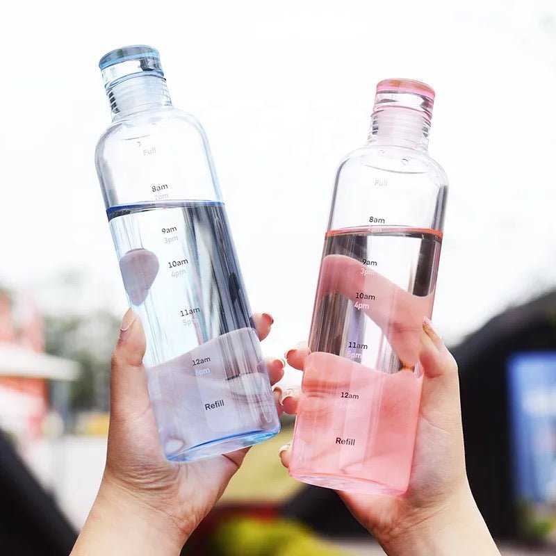 Woman holding glass time marker water bottles blue and pink