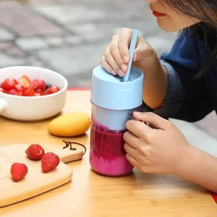 Woman drinking smoothie from portable rechargeable juicer blender cup