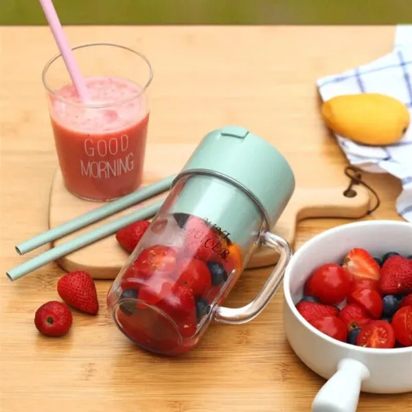 Portable juicer blender cup with fresh strawberries and straws